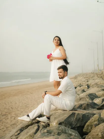 A serene moment on the rocks by the sea. This photo captures a peaceful pause during a romantic beach pre-wedding shoot.