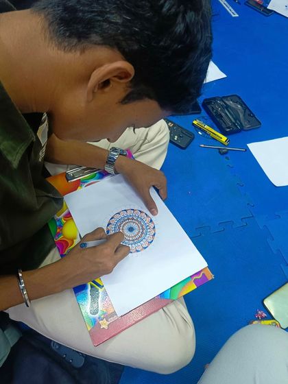 A student adding color to his dot mandala. My workshops cover various techniques, including how to use dotting tools and acrylics to create vibrant, textured pieces.