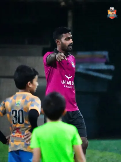 A coach points out instructions to his players during a training session, ensuring everyone understands their role and position.