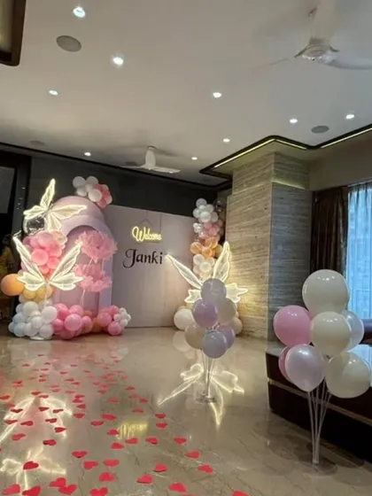Make their welcome home truly special with a full room transformation. This butterfly-themed decoration for 'Janki' includes a stunning balloon and prop backdrop, with a path of hearts on the floor and balloons throughout the living room, creating an immersive and joyful atmosphere.