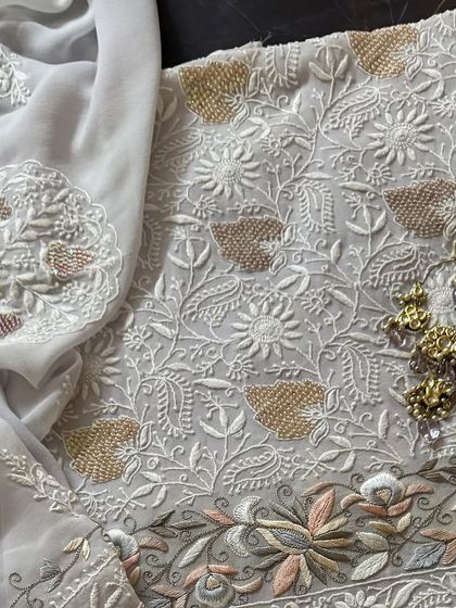 A flat-lay of the kurta and dupatta, styled with earrings.