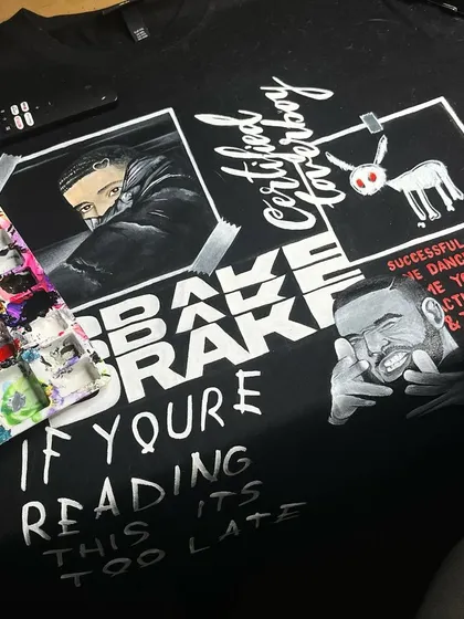 A custom t-shirt I painted with a collage of Drake album art, including 'Certified Lover Boy' and 'If You're Reading This It's Too Late'.