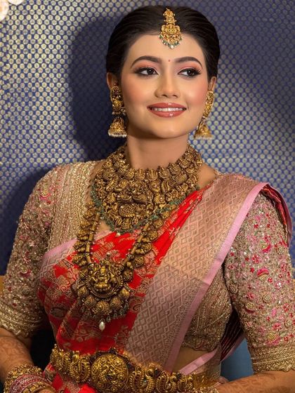 A stunning portrait of the bride, showcasing her complete look with heavy temple jewelry and a radiant, happy expression.