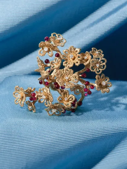 My cherry blossom statement ring, a piece inspired by my treks and the beauty of nature. It is handcrafted in 18k gold, with branches of blossoms wrapping around the finger, accented with tiny, no-heat Mozambique rubies that look like ripe cherries.
