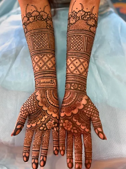 Personalizing your mehendi is what makes it truly yours. Here, I've beautifully hidden the groom's name, 'Hemanth', within the intricate cuff of the bridal design.