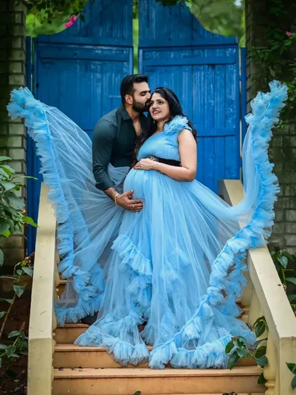 This sky-blue ruffled maternity gown is perfect for creating sweet and memorable couple portraits. The wing-like ruffles add a playful, angelic touch, and the color pops beautifully against any backdrop, like this charming blue door.