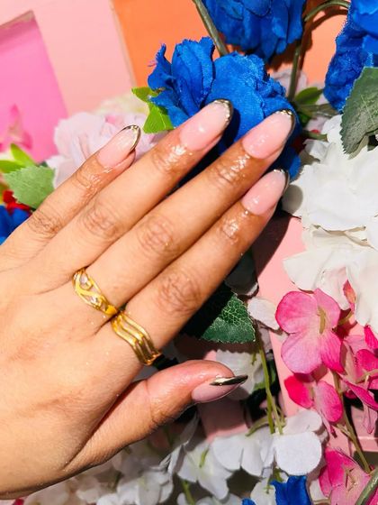 A close-up of the elegant chrome French tip, showing the clean application of the metallic gold line.