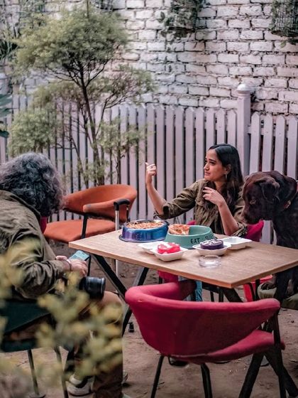 A guest and her dog enjoying a meal in our outdoor seating area. It's a perfect spot for a relaxed afternoon.