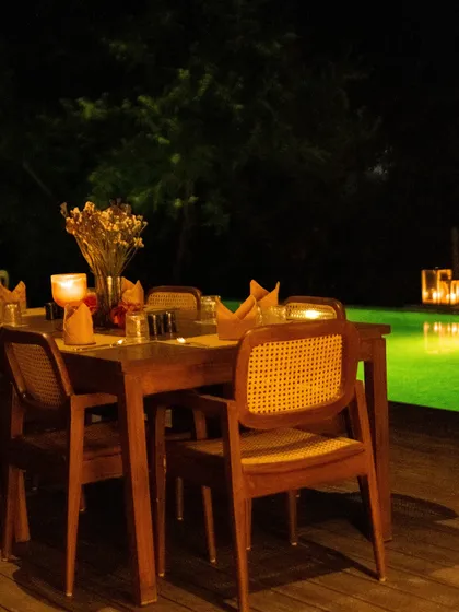 A cozy winter dinner setup by the glowing pool, an intimate and magical dining experience.