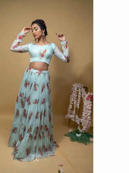 This baby blue floral printed lehenga is light, airy, and perfect for a summer wedding or festive brunch. The tiered skirt adds a playful, modern touch.