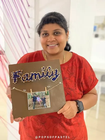A lovely string art piece that doubles as a photo frame, celebrating family with a personal touch.