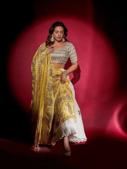A seated pose in the Faabiiana lehenga, highlighting the rich embroidery on the dupatta. This is a perfect rental for a traditional yet glamorous look.