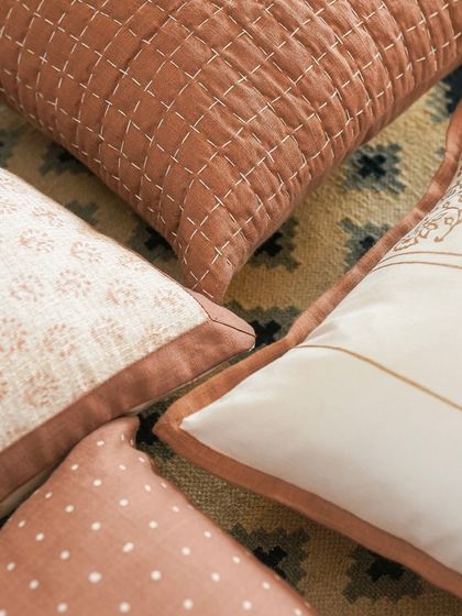 A close-up of our block printed cushion collection, highlighting the subtle imperfections that make each piece unique. The running stitch detail on the quilted cushion adds another layer of texture and craftsmanship.