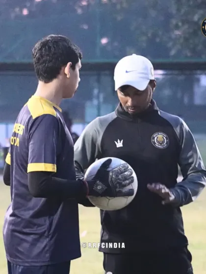 A coach provides one-on-one instruction to our goalkeeper. This personalized guidance is a core part of our coaching philosophy, ensuring players understand the finer details of their position.