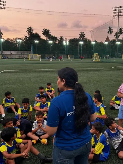 Young players listen intently as a sports psychologist speaks to them during a beautiful sunset session. We believe the mind is as important as the feet in football.