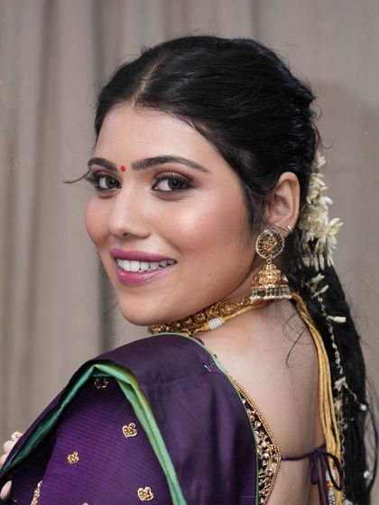 A happy, over-the-shoulder smile. This candid moment shows how the makeup looks natural and radiant, capturing her joyful spirit.