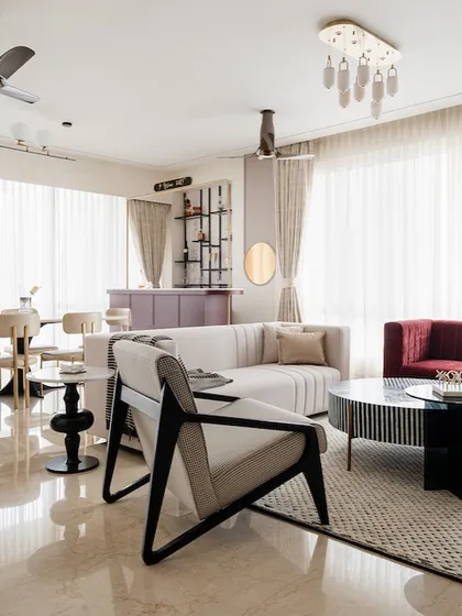 This living and dining space from our "Crimson Paradise" project is designed to feel like a quirky art gallery. A bold red sofa, a striped coffee table, and a custom bar create a vibrant, contemporary area for entertaining.
