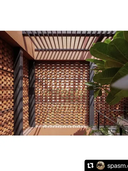 The play of light and shadow through a brick jali screen and a pergola. The filtered light creates ideal conditions for the lush underplanting, demonstrating our approach to climatic design.