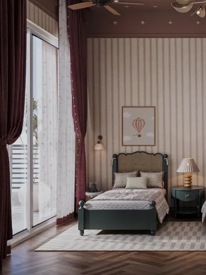 Heavy, deep red curtains frame a large window, adding a touch of drama and warmth to this shared bedroom. The natural light highlights the soft textures and gentle patterns used throughout the space, creating a cozy atmosphere.