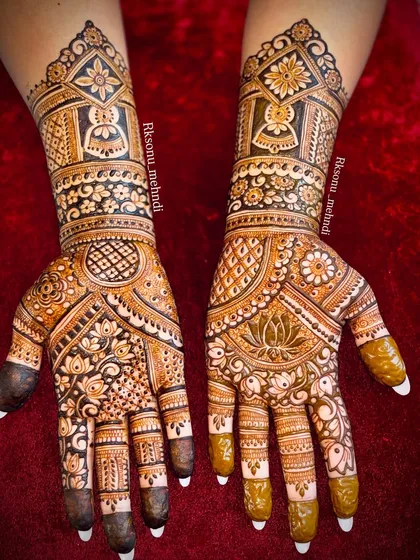 This is a wonderful example of full-coverage bridal mehndi, where both hands are adorned with a dense and symmetrical design. The use of bold lines and delicate fills creates a striking contrast, featuring geometric patterns and floral motifs for a classic bridal look.