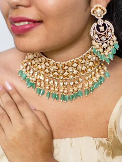 A close-up of a stunning kundan choker with mint-green bead droppings and pearl accents. This piece offers a fresh and elegant take on traditional bridal jewellery.