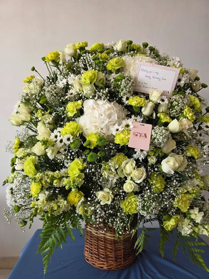 A full shot of the white and green arrangement, showing the personalized notes attached, ready for a birthday celebration.