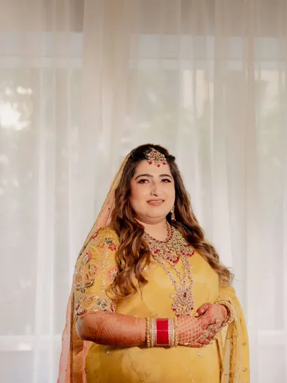 Capturing the joy of this bride's wedding ceremony. Her makeup is traditional and radiant, with warm tones and defined eyes, paired with soft waves for a look that is both classic and effortlessly beautiful.