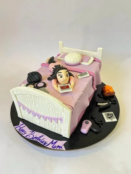 From the front, you can see the birthday message and the texture on the fondant bedspread. Every element is carefully crafted to tell a story.