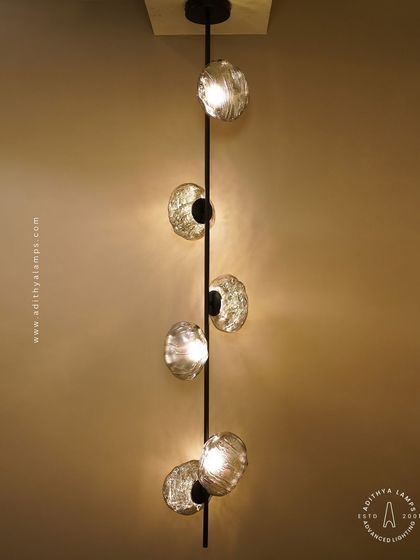 This vertical fixture features textured, moon-like chrome orbs attached to a central black rod. It's a striking, artistic piece that works well in corners or narrow spaces, adding a touch of celestial-inspired modernism.
