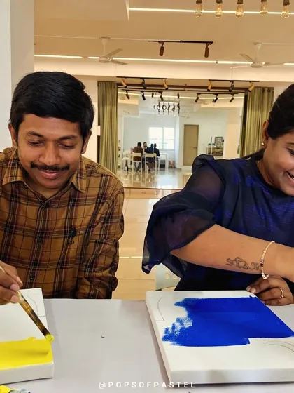 A happy couple painting side-by-side, enjoying a creative way to celebrate their anniversary.