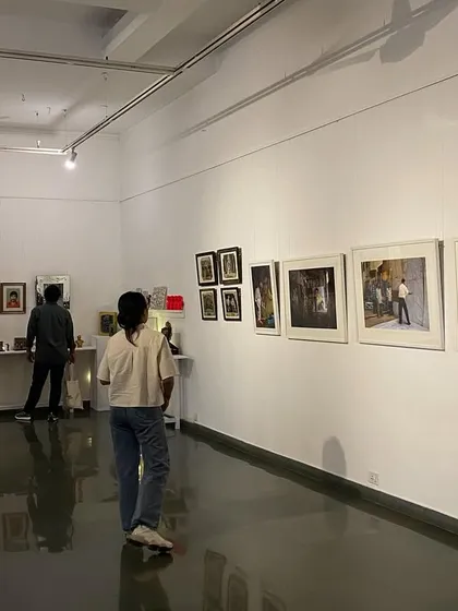 A visitor looking at the framed artworks in 'Southern Stars'.