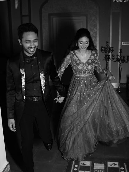 A joyful black and white photo of the couple, capturing their movement and happiness.