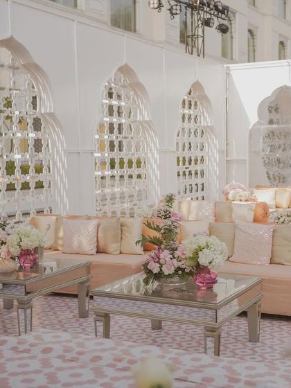 A seating area within the 'Mughal Garden' theme, featuring mirrored tables and custom-printed flooring that complements the intricate backdrops.