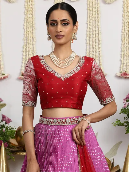 A close-up of the red embroidered blouse, featuring pearl detailing and brocade sleeves.