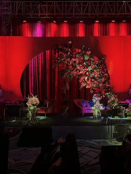 A lounge area with a curved magenta sofa set against a red backdrop with a circular cutout, showcasing our use of geometric shapes and bold color blocking.