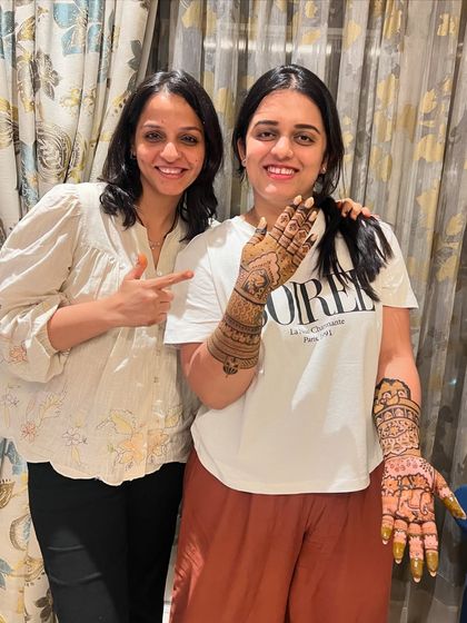 My partner Pinky with Devisha, showing the beautiful bridal mehndi we did for her sister's wedding. We work as a team to create these masterpieces.