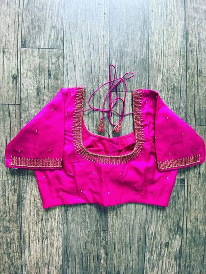 A simple and elegant pink silk blouse. It has a clean square neckline with a thin line of beadwork for a minimal look.