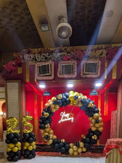 For a 25th anniversary, I created this elegant stage decoration. The setup includes a circular balloon arch in black and gold, a "Happy Anniversary" neon sign, and large foil number balloons, creating a perfect focal point for the celebration.