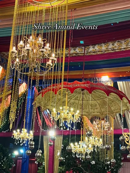 A colorful explosion of decor, featuring Rajasthani-style umbrellas and hanging chandeliers, perfect for a vibrant Sangeet or Dandiya night.
