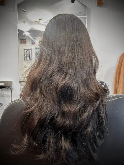 This final look shows the beautiful result of adding extensions. Her hair is not just longer, but also visibly fuller with natural-looking layers and waves.