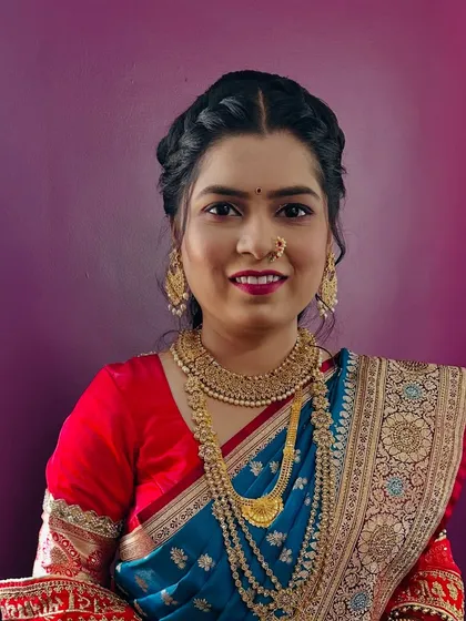 A happy bride is the most beautiful bride. This client is glowing in her Paithani saree, with a braided updo, traditional gold jewellery, and makeup that enhances her natural beauty.