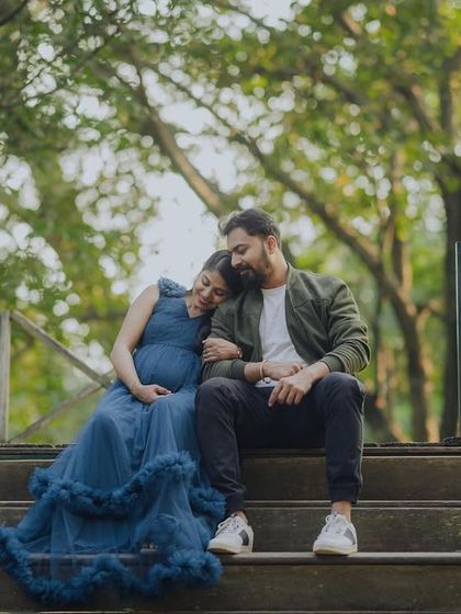 A wide shot of the couple relaxing together on a set of stairs in nature. This pose feels natural and comfortable, showing their easy connection.