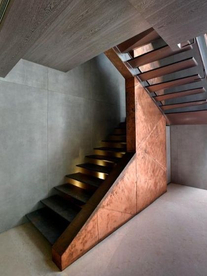 A view of the staircase from below, highlighting the warm glow of the integrated lighting on the cantilevered treads. The underside of the staircase is as thoughtfully designed as the top, revealing the structure's clean lines.