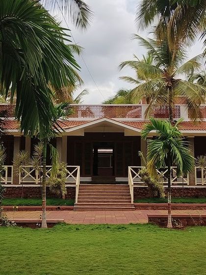 The grand entrance of the "Grid in the Grove" farmhouse, framed by the lush greenery of the coconut plantation. The design invites you into a space that is both a home and a part of the natural world.