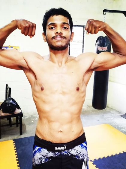 A front physique shot showing the results of dedicated strength and conditioning. A strong body is essential for a high-performance martial artist.