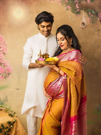 A tender moment between an expecting couple. The husband-to-be holds a traditional lamp, symbolizing light and hope, as they share a quiet moment together.