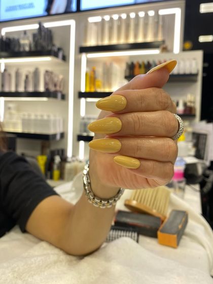 A simple and clean set of long almond nails in a beautiful mustard yellow color.