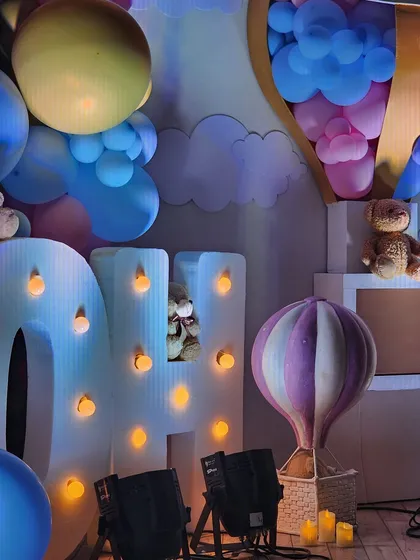 This whimsical baby shower featured large marquee letters, teddy bears nestled in pastel balloon clouds, and a custom hot air balloon prop, creating a dreamy and joyful atmosphere.