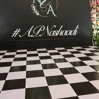 A custom hashtag for the couple, '#APNashaadi', displayed on a modern backdrop against a checkered dance floor. Personalized details like this make the event uniquely theirs.