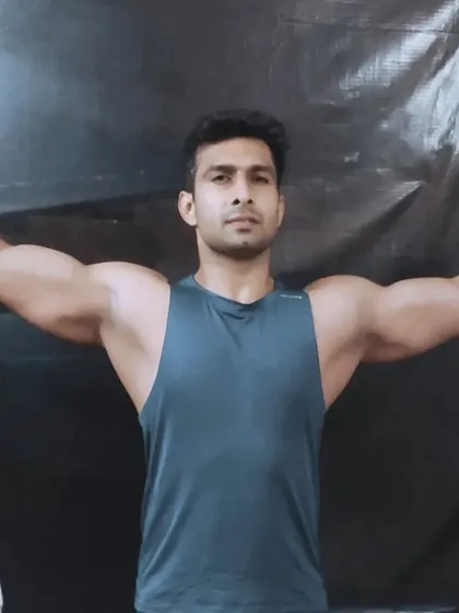 A front double bicep pose, showcasing shoulder and arm development. This is a result of consistent training and focusing on symmetrical muscle growth.